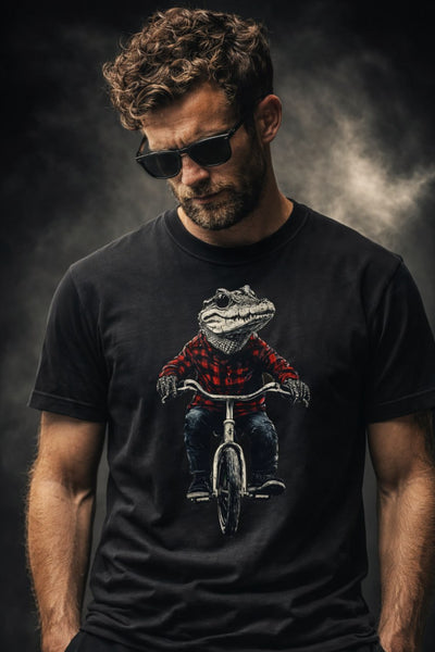 Man with curly brown hair, beard and sunglasses wearing black t-shirt featuring alligator in plaid shirt riding a bicycle graphic design