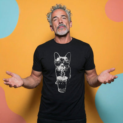 Man wearing a black t-shirt with a graphic design of french bulldog drinking bubble tea against a colorful polka dot background