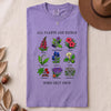 All Plants Are Edible Some Only Once Botanical Chart T-Shirt - Violet folded t-shirt mockup