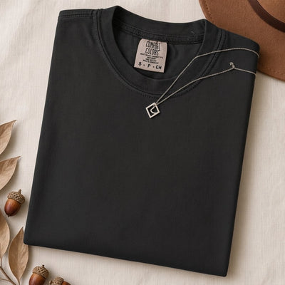 Just a t-shirt. Comfort Colors unisex garment-dyed heavyweight plain t-shirt with Radiant Art logo on right sleeve - Black folded t-shirt mockup