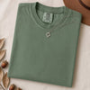 Just a t-shirt. Comfort Colors unisex garment-dyed heavyweight plain t-shirt with Radiant Art logo on right sleeve - Light Green folded t-shirt mockup