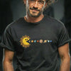 Man with curly brown hair and beard wearing black t-shirt featuring Pac-Man sun eating planets solar system graphic design