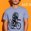 Man wearing a blue t-shirt with a graphic design of a lion riding a bicycle on an orange background.