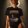 Woman modeling black graphic t-shirt with Lunar Landscaping Co. EST. 1969 astronaut mowing moon lawn design in dramatic studio lighting