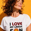 Woman with windswept wavy brown hair wearing white "I Love My Large Son" t-shirt with sun graphic